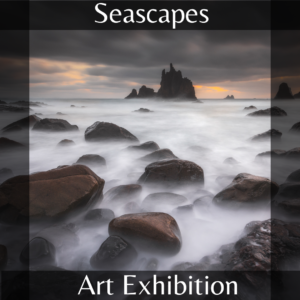 Picture of the waters edge with rocks and distant rock mountain formation. For the Seascapes Art Exhibition